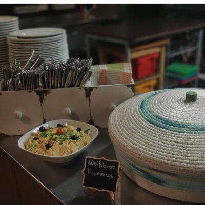 Veganes Hummus mit Oliven und Weißbrot als Vorspeise angerichtet