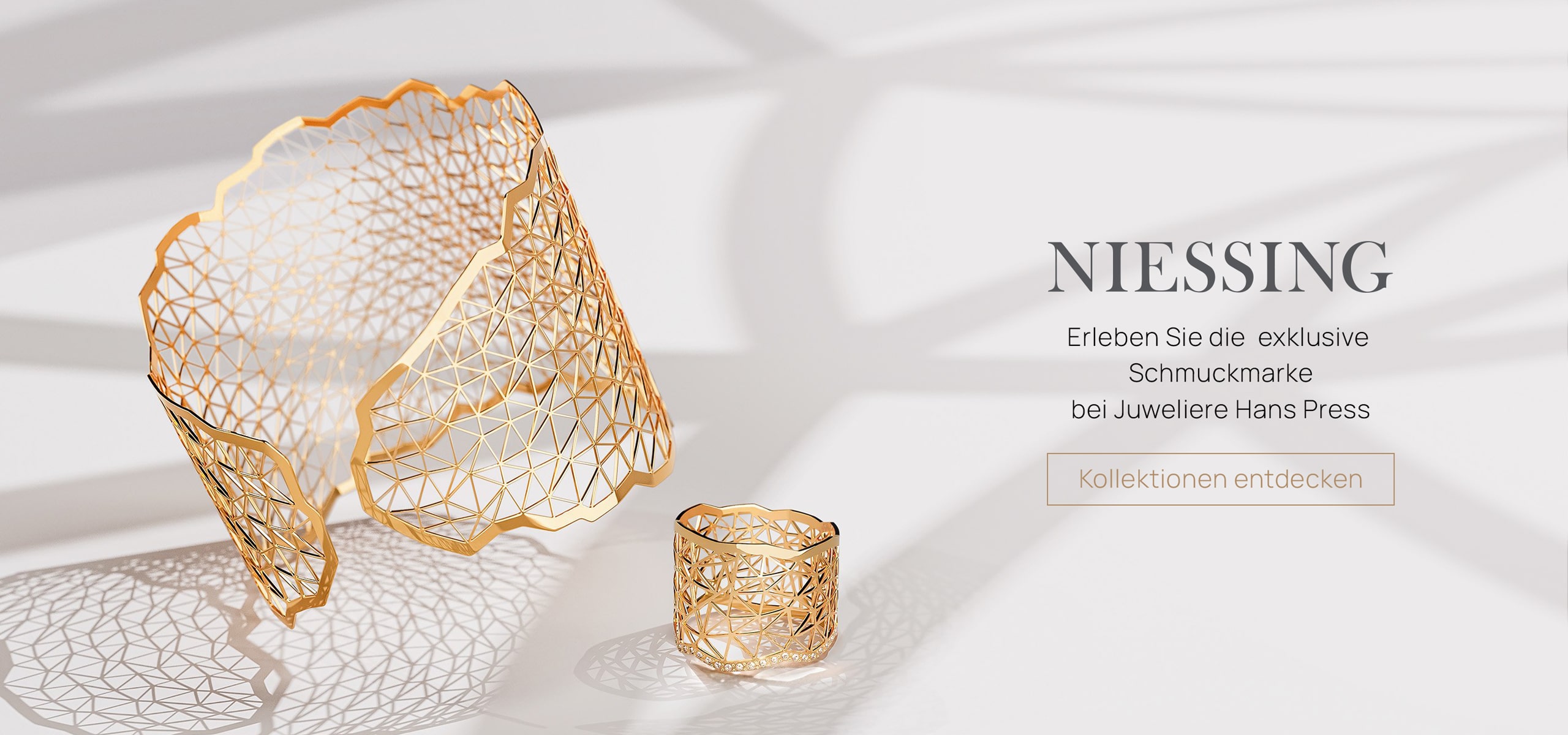 Ein goldenes, geometrisches Manschettenarmband und ein passender Ring werden auf hellem Hintergrund neben einem deutschen Text gezeigt, der die Niessing Schmuckkollektion bei Juwelliere Hans Press hervorhebt.
