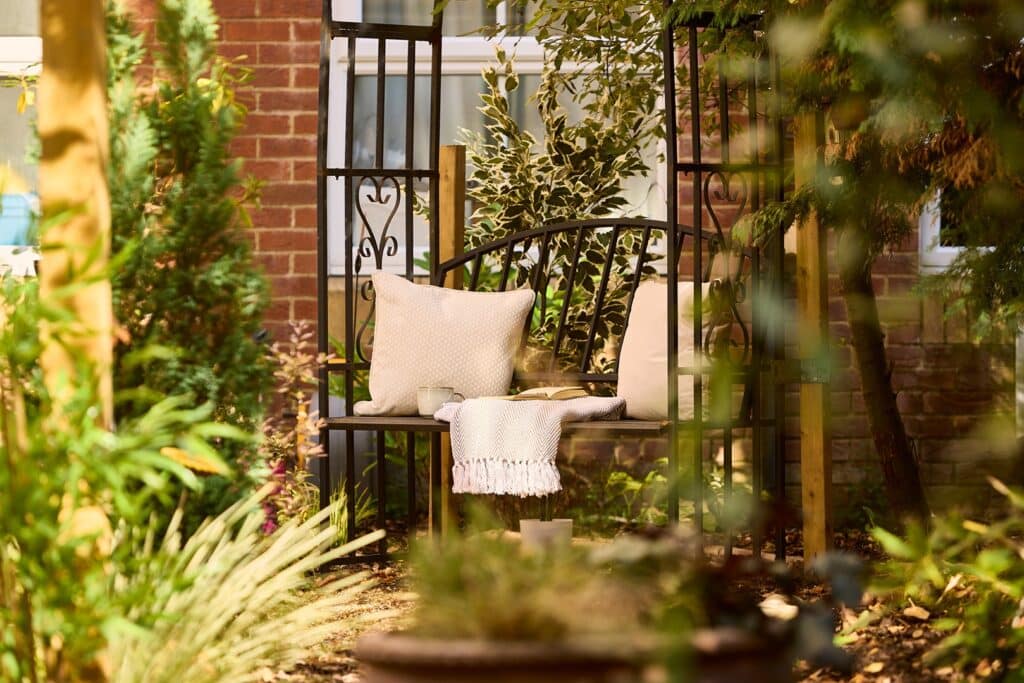 Cosy garden bench with cushions and blanket