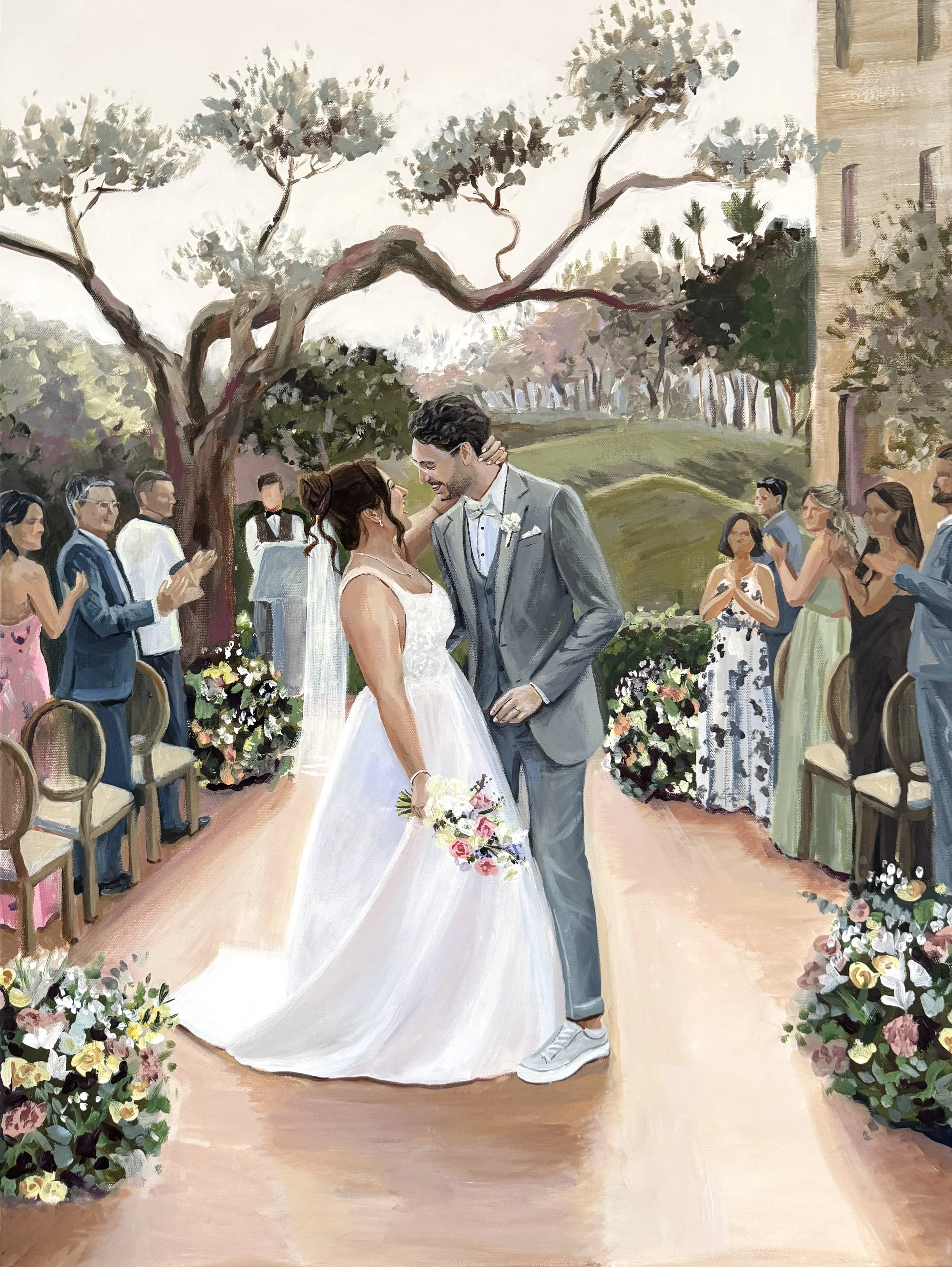Ein Brautpaar tanzt bei einer Hochzeit im Freien, umgeben von Gästen und Blumen, mit Bäumen im Hintergrund.