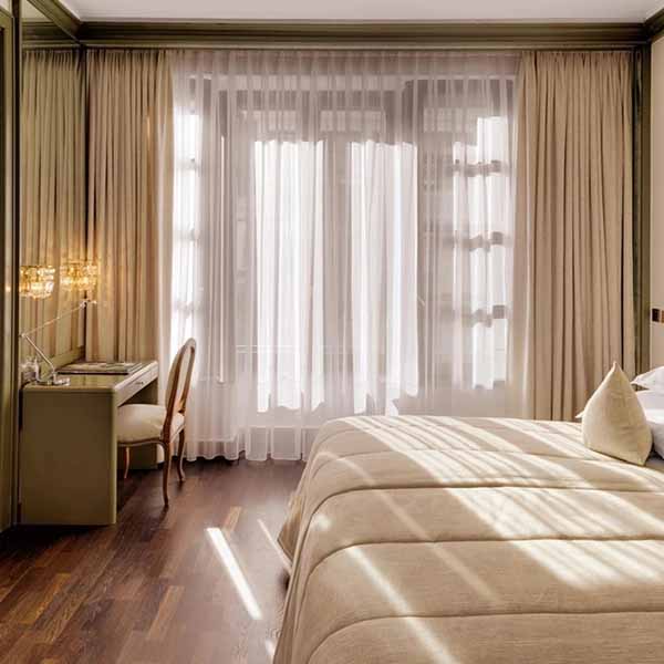 Schlafbereich der Executive Suite mit großem Bett und natürlichem Licht.