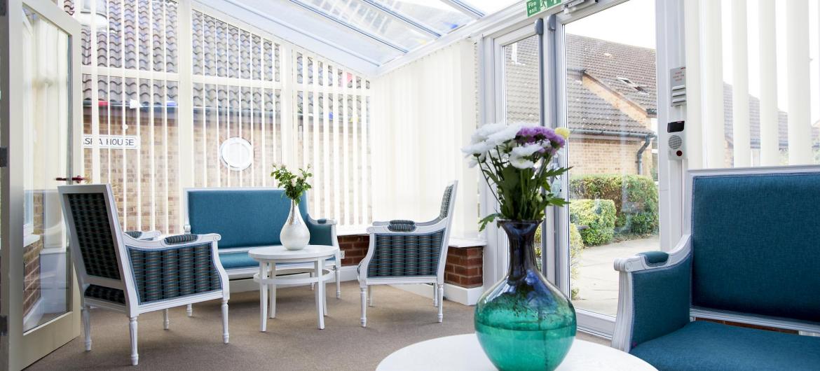 The conservatory provides plentiful seating to admire the gardens at Asra House Residential Care Home - links to YouTube video