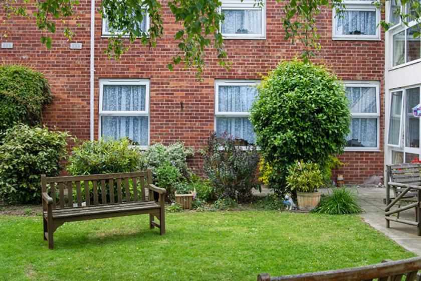Beautifully maintained gardens at Birchwood care home with benches.
