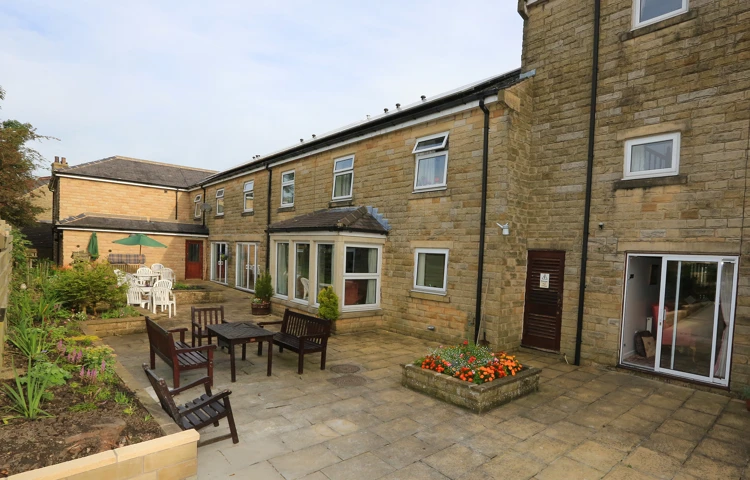 External view of paved courtyard and seating at Abbeyfield House, Clitheroe, BB7 2NH