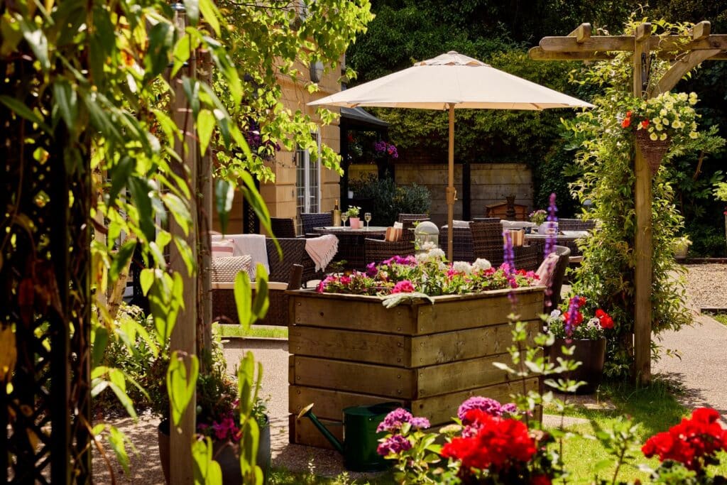 Outdoor garden seating area with colourful flowers.